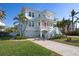 Stunning coastal home with an American flag on the balcony and well-manicured lawn and beautiful landscaping at 718 Key Royale Dr, Holmes Beach, FL 34217