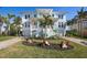 Beautiful two-story waterfront home with manicured lawn, lush landscaping, and a welcoming staircase at 718 Key Royale Dr, Holmes Beach, FL 34217