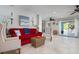 Comfortable living room with tiled floors, a red sofa, and access to an outdoor patio at 718 Key Royale Dr, Holmes Beach, FL 34217
