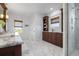 Bright main bathroom with marble countertop vanity, natural light, a glass shower, and custom cabinets for storage at 718 Key Royale Dr, Holmes Beach, FL 34217