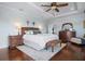 Comfortable main bedroom featuring a ceiling fan, hardwood floors and a seating area with a patterned bench and night stands at 718 Key Royale Dr, Holmes Beach, FL 34217