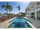 Stunning pool area features travertine deck, tropical landscaping, and waterfront views at 718 Key Royale Dr, Holmes Beach, FL 34217