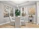 Bright dining area with glass table and four chairs, near a bar cart at 7946 Tybee Ct, University Park, FL 34201