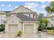Tan two-story townhome with two-car garage and lush landscaping at 7946 Tybee Ct, University Park, FL 34201
