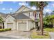 Two-story townhome with two-car garage, palm trees, and attractive landscaping at 7946 Tybee Ct, University Park, FL 34201