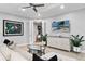 Living room with light-colored sofa and a large TV at 7946 Tybee Ct, University Park, FL 34201