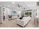 Open concept living room with white sectional sofa, hardwood floors, and access to a sunroom at 7946 Tybee Ct, University Park, FL 34201