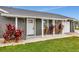 Front entrance with gray siding, white columns, and red plants at 905 69Th Nw St, Bradenton, FL 34209