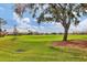 Scenic view of a lush green golf course with mature trees and homes in the background at 9414 Forest Hills Cir, Sarasota, FL 34238