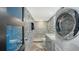 Small bathroom with patterned tile and stackable washer/dryer at 101 S Gulfstream Ave # 16J, Sarasota, FL 34236