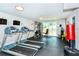 Well-equipped gym with treadmills, weight machines, and natural light from the sliding glass doors to an outdoor patio at 101 S Gulfstream Ave # 16J, Sarasota, FL 34236