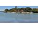Picturesque waterfront view with a tiki hut bar, boats, and a sandy beach along a tranquil bay at 101 S Gulfstream Ave # 16J, Sarasota, FL 34236