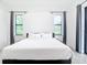 Spacious bedroom with king-size bed and two large windows at 10155 Hallendale Dr, Port Charlotte, FL 33981