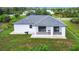 White house with gray roof, covered patio, and grassy backyard at 10155 Hallendale Dr, Port Charlotte, FL 33981