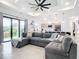 Bright living room with sectional sofa, open kitchen, and sliding glass doors leading to patio at 10155 Hallendale Dr, Port Charlotte, FL 33981