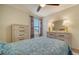 Charming bedroom with a ceiling fan and dresser, featuring a blue bedding set at 10916 Copperlefe Dr, Bradenton, FL 34212