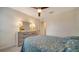 Charming bedroom with a ceiling fan and dresser, featuring a blue bedding set at 10916 Copperlefe Dr, Bradenton, FL 34212
