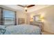 Charming bedroom with a ceiling fan and dresser, featuring a blue bedding set at 10916 Copperlefe Dr, Bradenton, FL 34212
