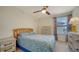 Cozy bedroom with a ceiling fan and dresser, featuring a blue bedding set at 10916 Copperlefe Dr, Bradenton, FL 34212