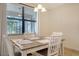 Cozy dining area with a wood table and four chairs, near a large window at 10916 Copperlefe Dr, Bradenton, FL 34212