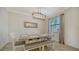 A dining room with a rustic table, bench seating, and a stylish chandelier at 10916 Copperlefe Dr, Bradenton, FL 34212