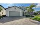 Two-story home with gray siding, two-car garage, and a paver driveway at 10916 Copperlefe Dr, Bradenton, FL 34212