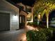 Night view of a luxury home's entryway with landscape lighting at 10916 Copperlefe Dr, Bradenton, FL 34212