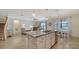 Island kitchen with granite countertops, white cabinets, and view of living room at 10916 Copperlefe Dr, Bradenton, FL 34212