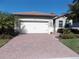 Well-maintained house with a paved driveway, landscaping, and a two-car garage at 11992 Blazing Star Dr, Venice, FL 34293