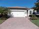 Well-maintained house with a paved driveway, landscaping, and a two-car garage at 11992 Blazing Star Dr, Venice, FL 34293