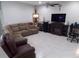 Spacious living room with a sectional sofa, large TV, and fireplace at 11992 Blazing Star Dr, Venice, FL 34293