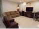 Spacious living room with a sectional sofa, large TV, and fireplace at 11992 Blazing Star Dr, Venice, FL 34293