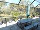 Screened patio with table, benches, and lush greenery views at 11992 Blazing Star Dr, Venice, FL 34293