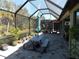Relaxing screened patio with table, benches, and potted plants at 11992 Blazing Star Dr, Venice, FL 34293