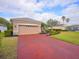 Tan house with red driveway and landscaping at 12338 Lavender Loop, Bradenton, FL 34212