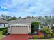 Tan house with red driveway, landscaping, and teal front door at 12338 Lavender Loop, Bradenton, FL 34212
