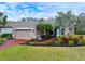 Tan house with red driveway, landscaping, and palm trees at 12338 Lavender Loop, Bradenton, FL 34212