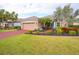 Tan house with red driveway and lush landscaping at 12338 Lavender Loop, Bradenton, FL 34212