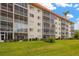 Exterior view of condo building with manicured lawn and screened-in balconies, perfect for enjoying the outdoors at 1600 1St W Ave # 304A, Bradenton, FL 34205