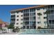 Exterior building view highlighting multiple screened balconies and a community pool at 1600 1St W Ave # 304A, Bradenton, FL 34205