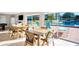 Bright recreation room with multiple tables and views of the sparkling blue swimming pool area and condo building at 1600 1St W Ave # 304A, Bradenton, FL 34205
