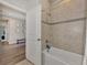 Well-lit bathroom with bathtub, shower, and a view of the hallway at 16257 S Port Harbor Blvd, Port Charlotte, FL 33953