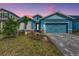 Two-story light blue house with a gray paved driveway and landscaping at 16257 S Port Harbor Blvd, Port Charlotte, FL 33953
