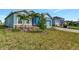 Landscaped front yard of a light blue house with palm trees at 16257 S Port Harbor Blvd, Port Charlotte, FL 33953