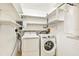 Bright laundry room with washer, dryer, and ample shelving at 2135 Hyde Park Cir, Sarasota, FL 34239