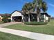 Two-car garage, manicured lawn, and palm trees at 2536 Marton Oak Blvd, North Port, FL 34289