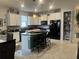 Modern kitchen with white cabinets, large island, and pantry at 2536 Marton Oak Blvd, North Port, FL 34289