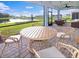 Screened patio with outdoor dining set overlooking lake at 25532 Royal Tern Ln, Englewood, FL 34223