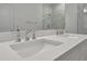Double vanity with modern faucets and white countertop at 25917 Bimini Sands Ct, Englewood, FL 34223