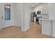 Modern entryway with light wood floors and a glass front door leading to the kitchen at 25917 Bimini Sands Ct, Englewood, FL 34223